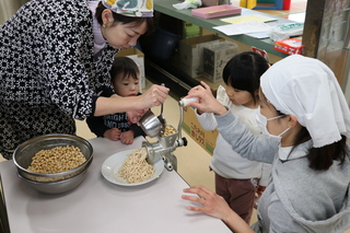 親子で大豆をつぶす様子