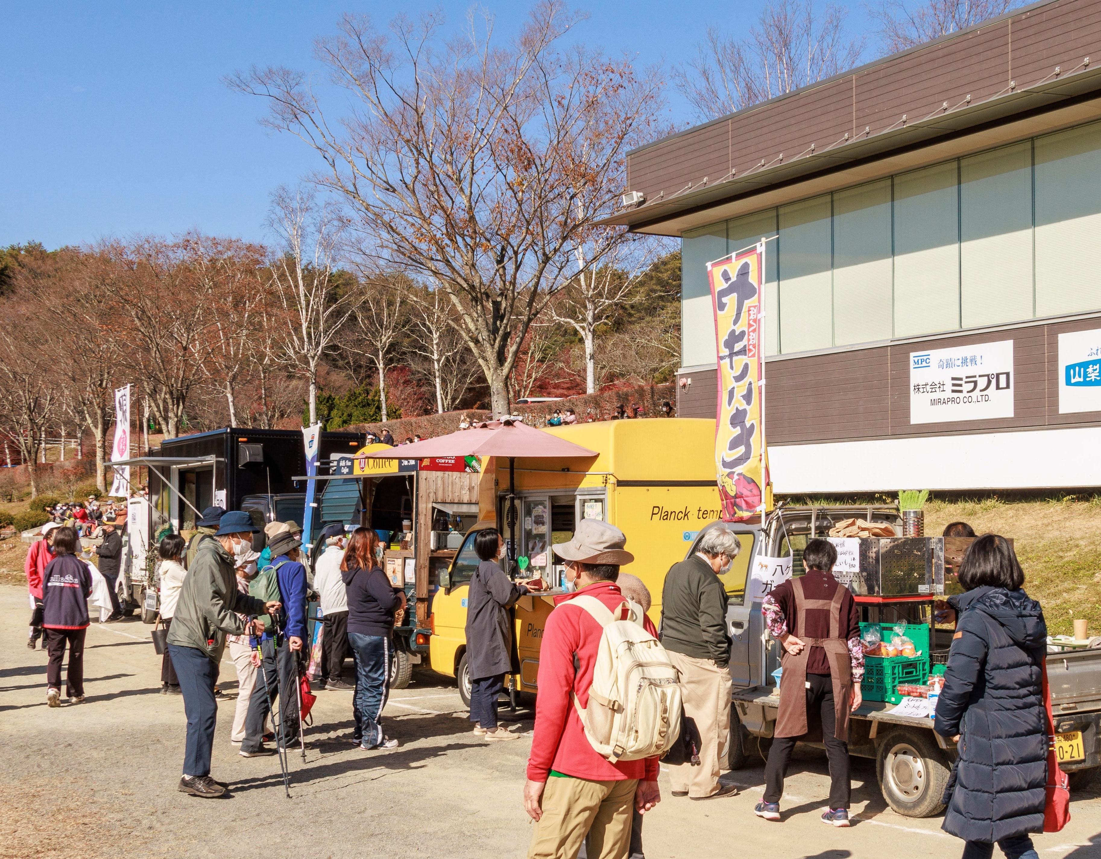 馬術競技場に出店されたハンドメイド雑貨や軽食を購入する参加者たち