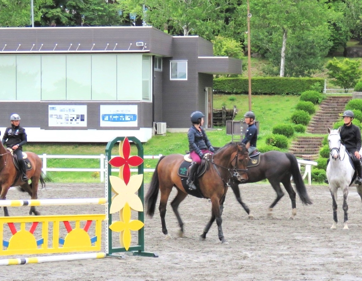 馬場でメンバー同士レッスンのアドバイスをする様子