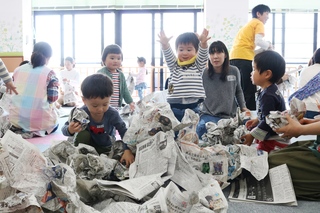 新聞紙で遊ぶ子ども